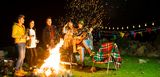 Gartenparty mit Gitarre und Lagerfeuer. Den Funkenflug beachtet niemand.